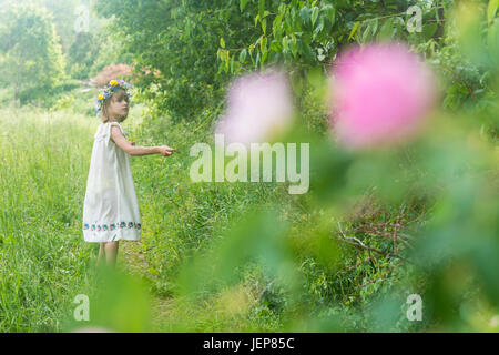 Mädchen tragen Blumen Kranz auf Wiese Stockfoto