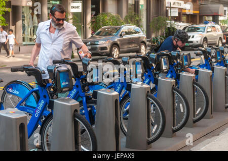 New York, USA Radfahrer wählen und wieder Fahrräder an einer Station CitiBike im Stadtteil Soho von Manhattan. Stockfoto