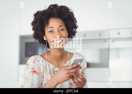 Lächelnde Frau mit Kopfhörern mit smartphone Stockfoto