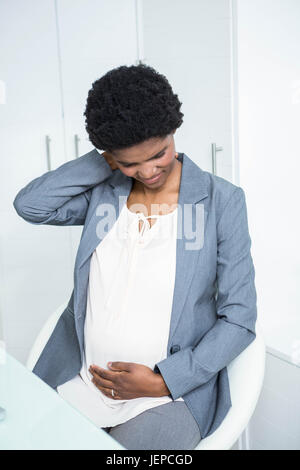 Schwanger Geschäftsfrau mit Nackenschmerzen Stockfoto