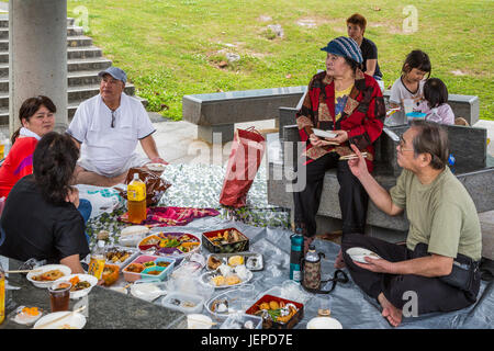 Eine japanische Familie mit einem Picknick in der Okinawa Präfektur Friedensmuseum in Itoman, Okinawa, Japan. Stockfoto