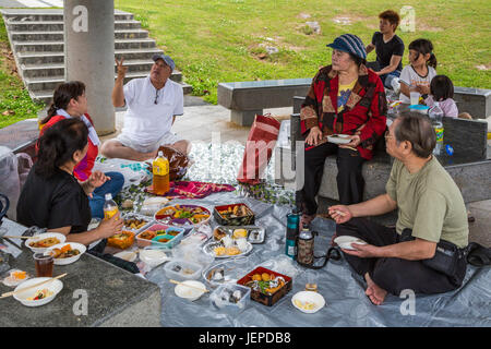 Eine japanische Familie mit einem Picknick in der Okinawa Präfektur Friedensmuseum in Itoman, Okinawa, Japan. Stockfoto