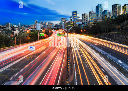 Breite Multi Lane Warringah Autobahn gehen durch North Sydney bei Sonnenuntergang mit unscharfen fahrenden Autos verlassen gelbe rote Linien der Lichter. Stockfoto