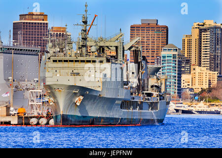 Vorderen Teil ihrer Majestät australische Schiffes bei militärischen Marinebasis in Sydney Cove an einem sonnigen Tag gegen Hochhaus Wohnhäuser. Stockfoto