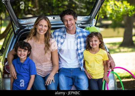 Lächelnd Familie sitzen in den Kofferraum Stockfoto