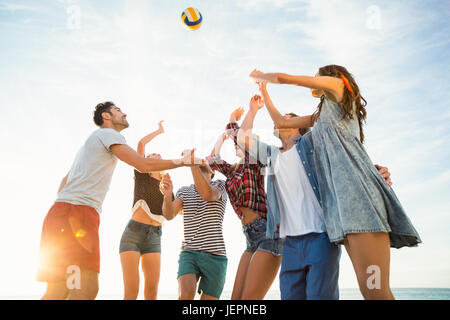 Freunde versuchen, Volleyball fangen Stockfoto