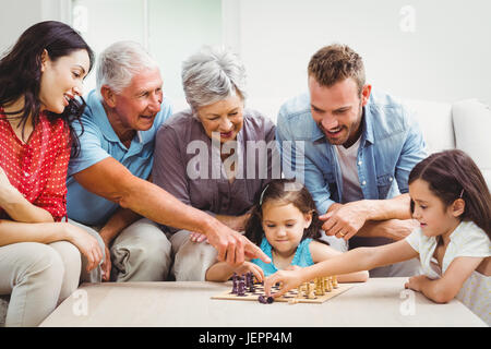 Lächelnde Familie Schach spielen Stockfoto