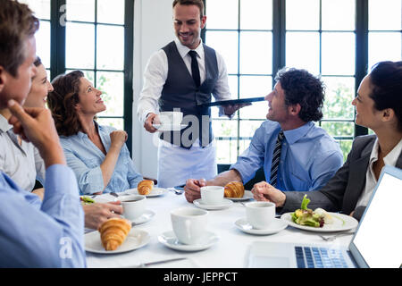 Kellner serviert Kaffee für Geschäftsleute Stockfoto