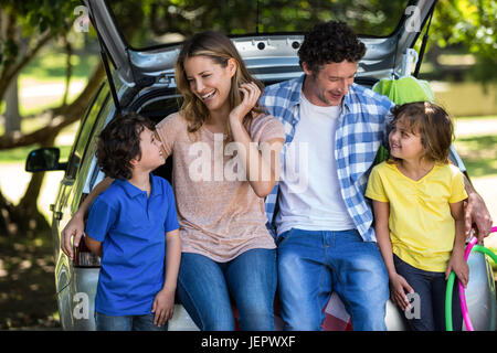 Lächelnd Familie sitzen in den Kofferraum Stockfoto