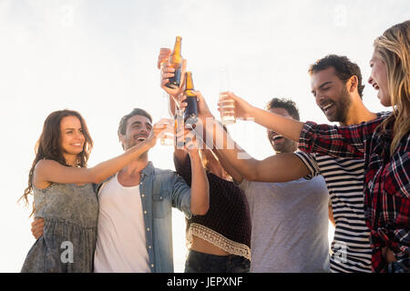 Glückliche Freunde Anhebung Bierflaschen Stockfoto