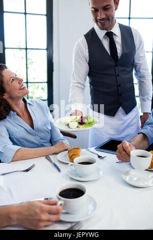 Kellner servieren Salat für Geschäftsleute Stockfoto