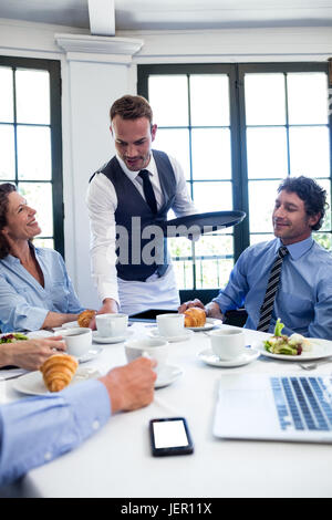 Kellner serviert Kaffee für Geschäftsleute Stockfoto