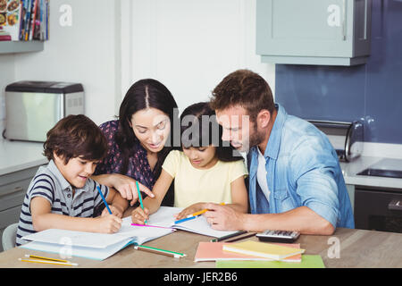Eltern, die Hilfe für Kinder in Hausaufgaben Stockfoto