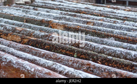 Bild von Schnee bedeckten Protokollen am Sägewerk Stockfoto