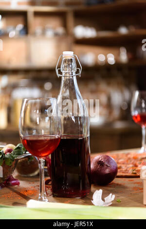 Küchentisch mit Nahrungsmitteln und Getränken. Frische Pizza, Rotwein und Gemüse bereit für House-party Stockfoto