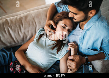 Hübsche junge Mädchen auf ihrem hübschen Freund Schoß liegend Stockfoto