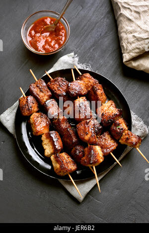 Hausgemachte gegrilltes Schweinefleisch-Spieße auf schwarzem Hintergrund, Ansicht von oben Stockfoto