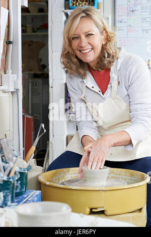 Porträt von Reife Frau, die Arbeiten an der Töpferscheibe In Studio Stockfoto
