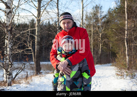 Porträt von umarmt Reife Vater und Sohn in warme Kleidung im Winterwald Stockfoto