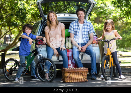 Lächelnde Familie vor einem Auto Stockfoto