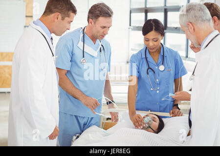 Ärzte, die Patienten eine Sauerstoffmaske aufsetzen Stockfoto