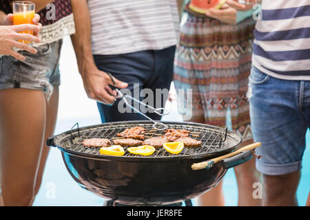 Den mittleren Abschnitt der Freunde Grill vorbereiten Stockfoto