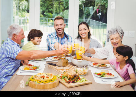 Lächelnde Familie Toasten Saft Stockfoto