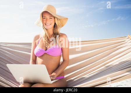 Frau mit ihrem Laptop in Hängematte Stockfoto