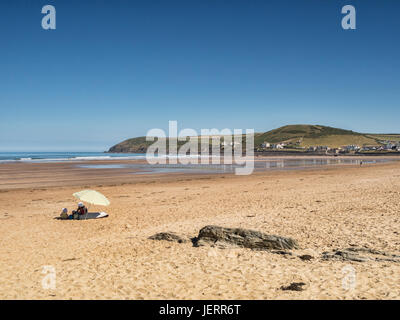 18. Juni 2017: Croyde Bay, North Devon, England, Uk - Mutter und Kleinkind unter einem Sonnenschirm in ein ruhigen Plätzchen am Strand von Croyde Bay, auf einer der Stockfoto