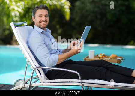 Kluger Mann mit digital-Tablette in der Nähe von Schwimmbad Stockfoto