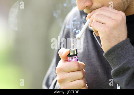 Nahaufnahme eines Teen Hände halten ein Feuerzeug eine Zigarette zu rauchen bereit Stockfoto