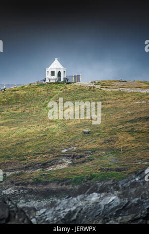 Dunkle Regenwolken über eine kleine weiße Suche Gebäude an der Oberseite Towan Landzunge in Newquay, Cornwall. Stockfoto