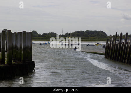 Ein Mann in einem Schlauchboot-Reihen gegen eine steife Brise auf der Slipanlage im Hafen von Bosham in West Sussex Stockfoto