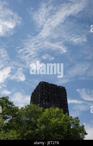 Zwölf Tage nach dem verheerenden Brand, der eine unbestimmte Zahl von Personen in Grenfell Turm, tötete bleibt das verkohlte und geschwärzte Hochhaus einem Tatort, am 26. Juni 2017, im Londoner Stadtteil Kensington & Chelsea, England. Stockfoto