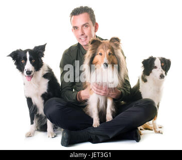 drei Hunde und Mensch vor weißem Hintergrund Stockfoto