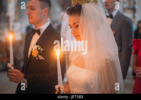 Die close-up horizontale Porträt des Brautpaares halten Kerzen während der Hochzeitszeremonie. Stockfoto