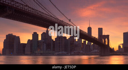 Brooklyn Bridge mit der New Yorker Skyline im Hintergrund, bei Sonnenuntergang fotografiert.