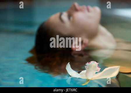 Europa, Italien, Helvetia Thermal SPA Hotel Porretta Terme, Modell Schwimmen im Thermalbad mit einer Orchidee schwimmende Stockfoto