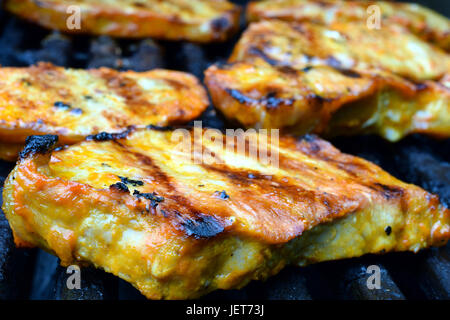 Nahaufnahme von Schweinefleisch Steaks auf ein Gas-grill Stockfoto