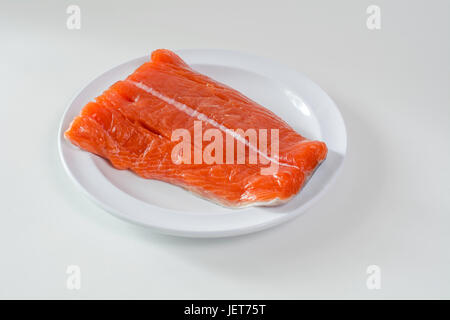 Rohe König Wildlachs Filet liegend auf weißen Platz, vor weißem Hintergrund Stockfoto