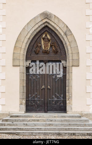 Alte hölzerne Eiche gewölbte gotische Kirche Türöffnung mit schwarzen schmiedeeisernen Scharnieren. große Holztür mit schmiedeeisernen Elementen. Dekorative Tür mit Verschraubung Stockfoto