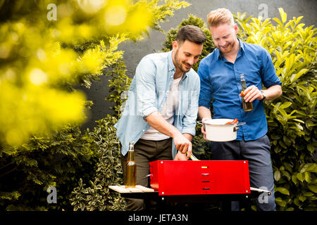 Blick auf zwei junge Männer, die Vorbereitung der Grill im Hof Stockfoto