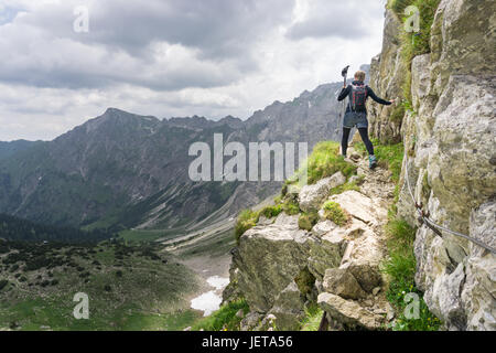 Frau geht Auf gefährlichen Spuren in der alpinen Bergwelt. Stockfoto