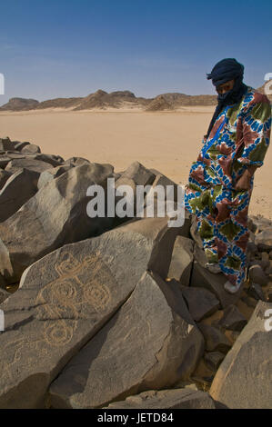 Mann schaut Galle Gravuren in der Tadrat-Wüste mit Tasset, Algerien, Afrika, Stockfoto