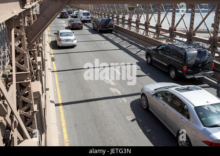 Verkehr Fahrzeuge fahren über die verschlissene Asphalt auf Brooklyn Brücke New York City USA Stockfoto