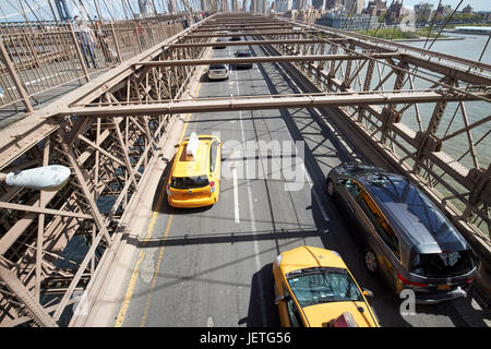 gelben Taxis Verkehr Fahrzeuge fahren über die verschlissene Asphalt auf der Brooklynbridge in New York City USA Stockfoto