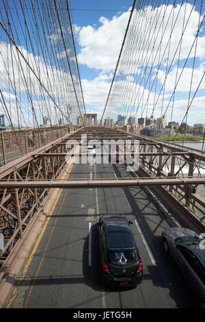 Verkehr Fahrzeuge fahren über die verschlissene Asphalt auf Brooklyn Brücke New York City USA Stockfoto