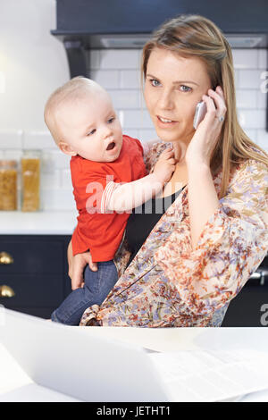 Mutter mit Baby beschäftigt Umgang mit stressigen Tag zu Hause Stockfoto