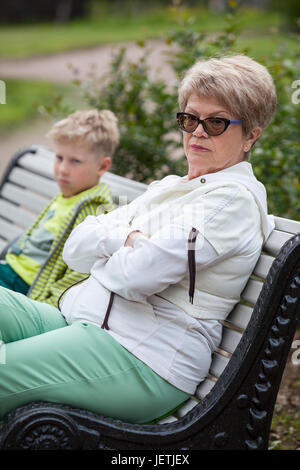 Großmutter und Enkel schwierige Beziehungen: unglückliche junge und traurige senior Frau befinden sich auf der Bank im Park Stockfoto