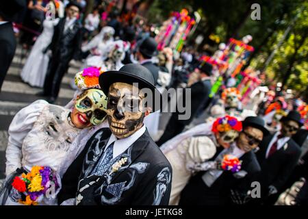 Junge Paare, kostümiert als La Catrina, einer mexikanischen pop-Kultur-Symbol für den Tod, Fuß durch die Stadt während des Tages der Toten Festlichkeiten in Mexico City, Mexiko, 29. November 2016. Tag der Toten (Dia de Muertos), einer synkretistischen religiösen Feiertag | weltweite Nutzung Stockfoto